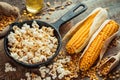 Prepared popcorn in frying pan, corn seeds and corncobs Royalty Free Stock Photo