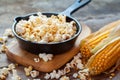 Prepared popcorn in frying pan, corn seeds and corncobs Royalty Free Stock Photo
