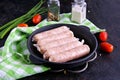 Prepared raw chicken or pork sausages in a cast-iron frying pan Royalty Free Stock Photo