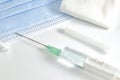 Prepared syringe with needle, sterile gauze, and surgical mask.