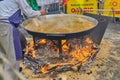 Prepares a delicious paella in a traditional large pan on the street during Las Fallas festival
