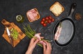 Preparing bacon wrapped asparagus on dark table.  Woman cooking asparagus. Ingredients for cooking on black background Royalty Free Stock Photo