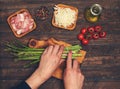 Preparing bacon wrapped asparagus on dark table.  Woman cooking asparagus. Ingredients for cooking on black background Royalty Free Stock Photo