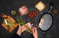 Preparing bacon wrapped asparagus on dark table.  Woman cooking asparagus. Ingredients for cooking on black background Royalty Free Stock Photo