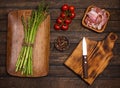 Preparing bacon wrapped asparagus on wooden table.  Cooking asparagus. Ingredients for cooking on wooden background Royalty Free Stock Photo