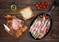 Preparing bacon wrapped asparagus on wooden table.  Cooking asparagus. Ingredients for cooking on wooden background Royalty Free Stock Photo