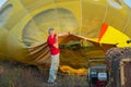 Preparing the baloon. hot air. big baloon. flight. come fly with me. in the field. yellow baloon. summer fun. a men holding baloo