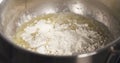 Preparing bechamel sauce adding flour