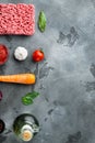 Preparing Bolognese sauce ingredients, minced meat, tomatoe, herbs, on gray stone background, top view, flat lay, with copy space Royalty Free Stock Photo