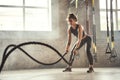 Preparing for the competition. Young athletic woman with perfect body doing crossfit exercises with a rope in the gym. Royalty Free Stock Photo