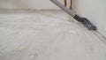 Preparing the concrete floor for priming with a vacuum cleaner. Worker cleaning floor with vacuum cleaner from industrial concrete Royalty Free Stock Photo