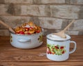 Preparing for cooking apple jam, sliced apples and sugar in an enamel bowl with fruit drawings on the rustic table Royalty Free Stock Photo