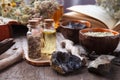 Preparing cosmetic black mud mask in ceramic bowl on vintage wooden background. Front view of facial clay emulsion on table with