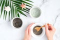 Preparing cosmetic clay mask in bowl. Natural organic SPA beauty products on marble background, facial skin care concept