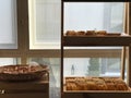Image of breads, pastries, neatly arranged on baskets and shelves.