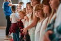 Preparing for a dance class. Group of cute and positive children with young female teacher standing at the dance studio Royalty Free Stock Photo