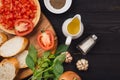 Preparing delicious Italian tomato bruschetta with chopped vegetables, herbs and oil Royalty Free Stock Photo