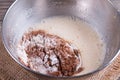 Preparing a dough/batter for crepes or pancakes with wheat flour and cocoa in bowl, milk, eggs and oil Royalty Free Stock Photo