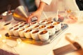 Preparing for a festive banquet. Serving the buffet table with dessert cakes. Female hands are laying out dessert spoons.