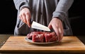 Preparing filet mignon. Female hands cutting meat for cooking