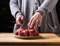 Preparing filet mignon. Female hands cutting meat for cooking