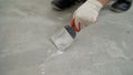 Preparing the floor for pouring and leveling. Floor repair in the apartment. The master cleans the floor with a spatula