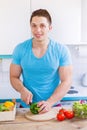 Preparing food cut vegetables young man healthy meal in the kitchen portrait format eating Royalty Free Stock Photo