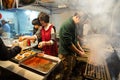 Preparing food in a small Asian food stall at night