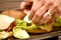 Preparing fresh tasty cheese burgers, closeup of woman hands