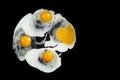 Preparing and frying four eggs in oil, isolated on black