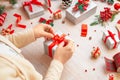 Preparing gifts for Christmas and New Year. The girl prepares a gift by tying a bow