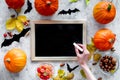 Preparing for halloween. Black desk for notes among pumpkins and bats on grey background top view mockup