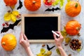 Preparing for halloween. Black desk for notes among pumpkins and bats on grey background top view mockup