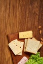 Preparing ham sandwiches for scool lunchbox on wooden background, close up.