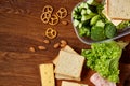 Preparing ham sandwiches for scool lunchbox on wooden background, close up.