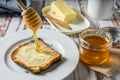 Preparing a healthy breakfast with a toast with butter and pure organic honey from bees Royalty Free Stock Photo