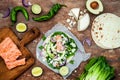 Preparing healthy lunch snacks. Fish tacos with grilled salmon, red onion, fresh salad leaves and avocado cilantro sauce Royalty Free Stock Photo