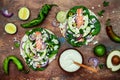 Preparing healthy lunch snacks. Fish tacos with grilled salmon, red onion, fresh salad leaves and avocado cilantro sauce Royalty Free Stock Photo