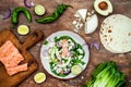 Preparing healthy lunch snacks. Fish tacos with grilled salmon, red onion, fresh salad leaves and avocado cilantro sauce Royalty Free Stock Photo