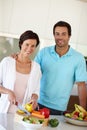 Preparing a healthy meal together. a man standing beside his wife as shes chopping vegetables at the kitchen counter. Royalty Free Stock Photo