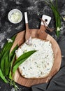 Preparing healthy vegetarian sandwiches on dark rustic table. Soft cheese dip on flatbread and fresh wild garlic leaves.