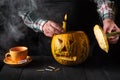 Preparing for the holiday - Halloween lantern cut out of pumpkin close-up. Burning candle in a man is hand Royalty Free Stock Photo