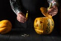 Preparing for the holiday - Halloween lantern cut out of pumpkin close-up. Burning candle in a man is hand Royalty Free Stock Photo