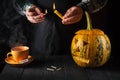 Preparing for the holiday - Halloween lantern cut out of pumpkin close-up. Burning candle in a man is hand Royalty Free Stock Photo