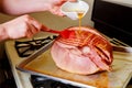 Preparing holiday spiral sliced pork ham with honey glaze Royalty Free Stock Photo