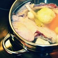 Preparing homemade chicken soup - broth. Pot on the stove in the kitchen with ingredients for cooking. Royalty Free Stock Photo