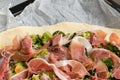 Preparing homemade pizza with vegetables and raw ham