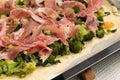 Preparing homemade pizza with vegetables and raw ham