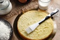 Preparing and impregnation with a milk of biscuit with a silicone brush. Baking a sponge biscuit cake. Cooking homemade Royalty Free Stock Photo