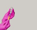 Preparing an injection. Picking medicine from jar into syringe. Hands in purple rubber gloves